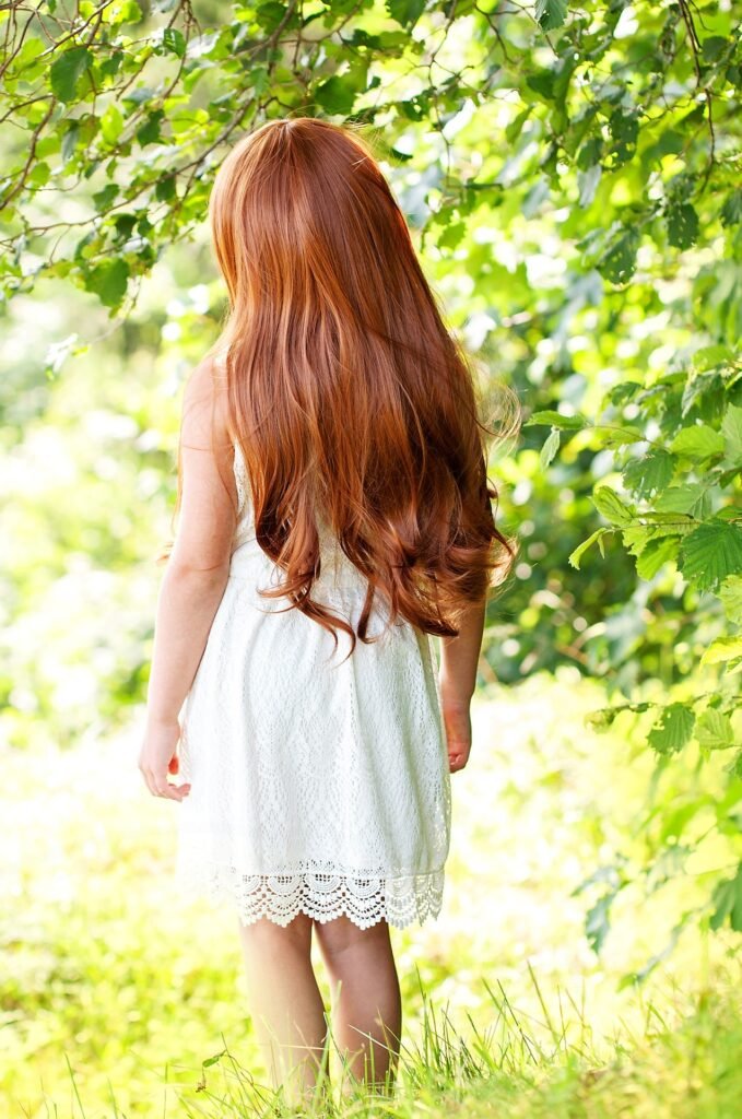girl in white pretty dress and healthy long hair in nature.