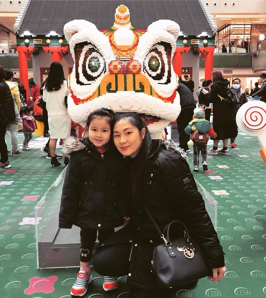 Lei Hang and daughter Yasmin in front of a giant golden Chinese dragon lego sculpture in New Town Plaza shopping Mall in Hong Kong, Sha Tin