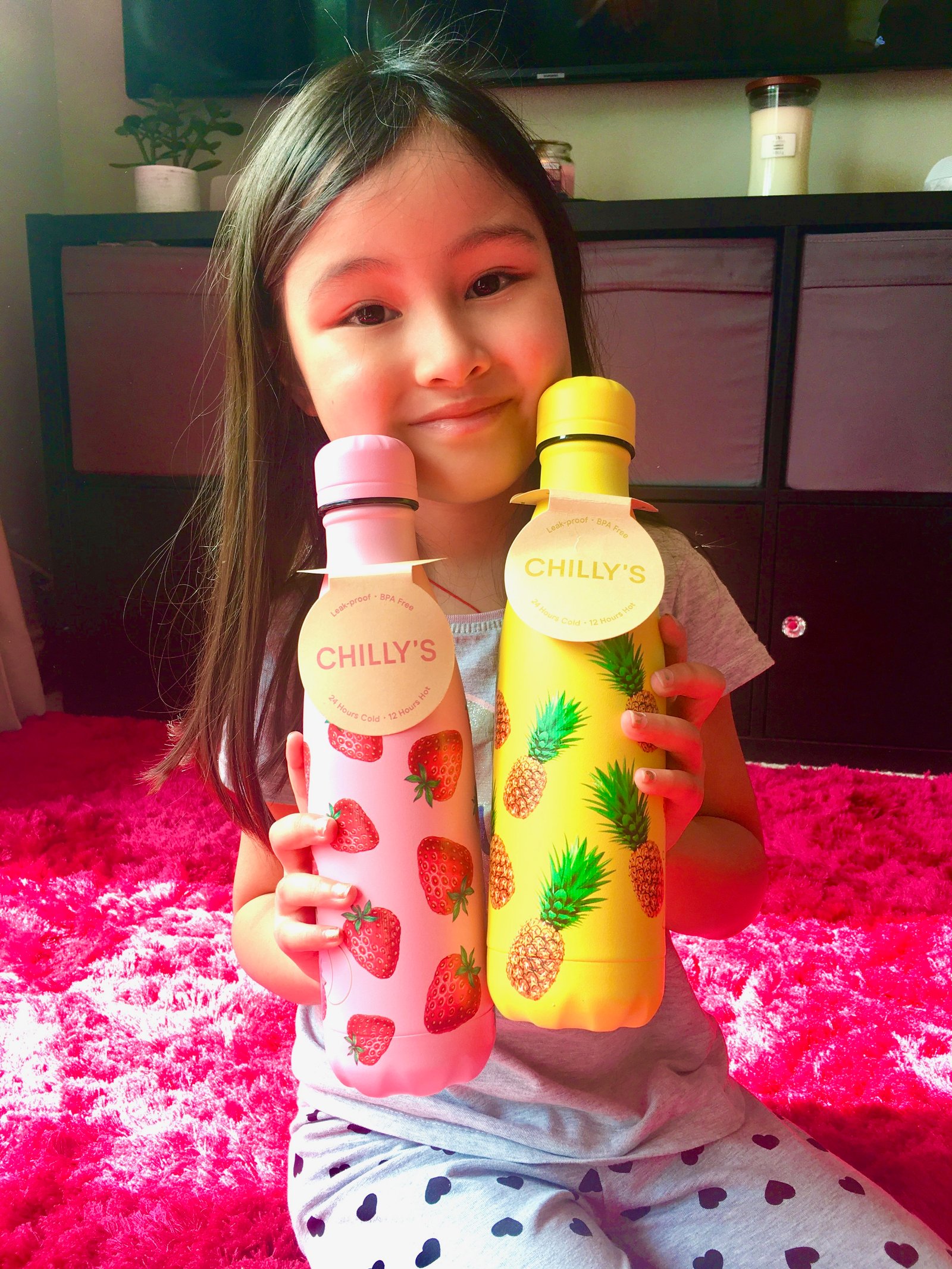 Lei Hang bought a Strawberry Chilly's bottle for herself and a Pineapple Chilly's bottle for Yasmin. Yasmin is happily showing the fruit monogram stainless steel flask water bottles.